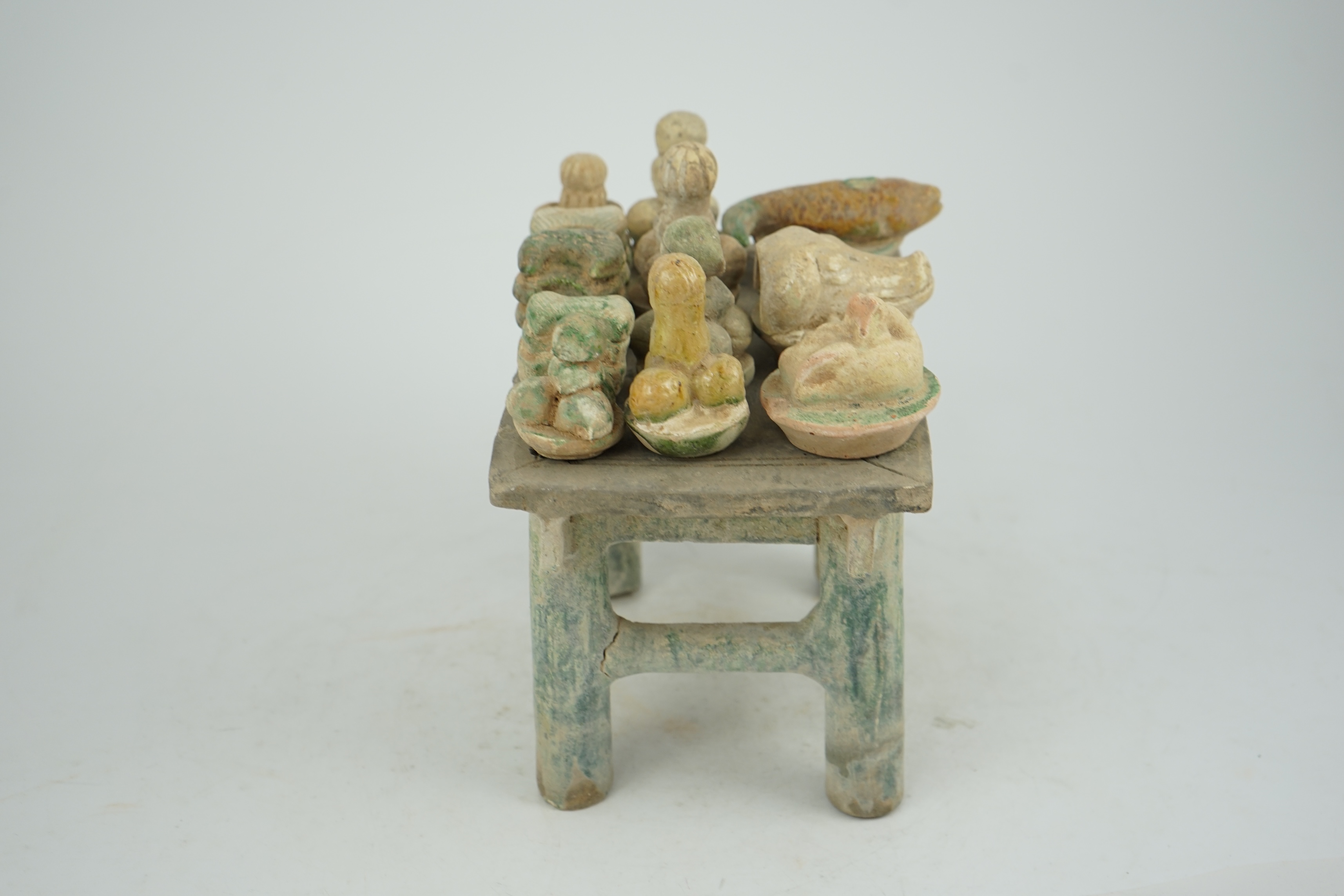 A Chinese glazed pottery altar table with food offerings, Ming Dynasty, c.1550-1600